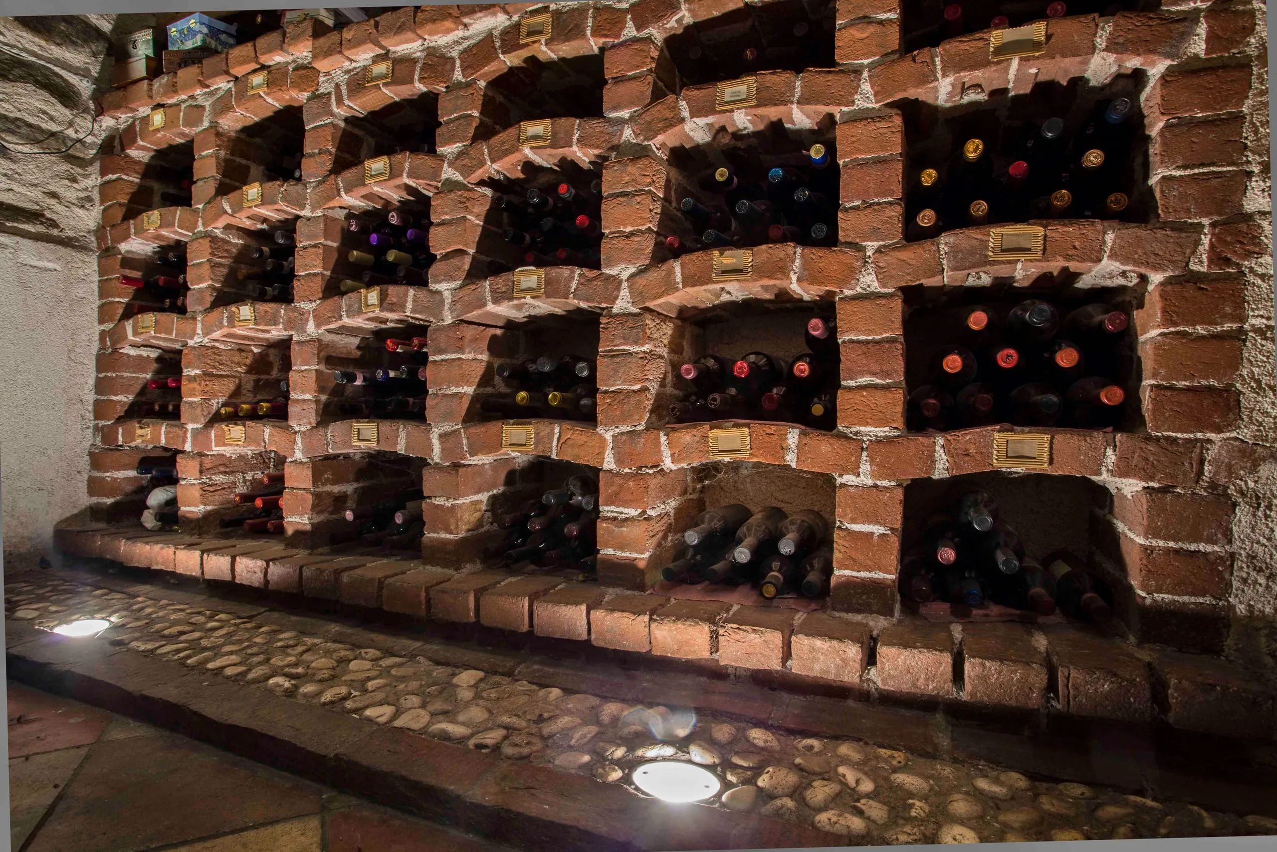 Nicchie in mattoni con le bottiglie della cantina