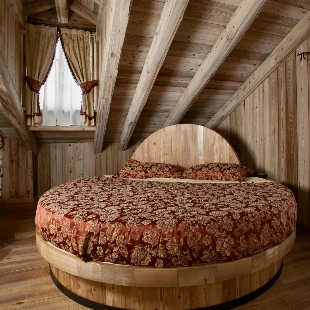 Letto rotondo della suite Archimede tra i tronchi di betulla