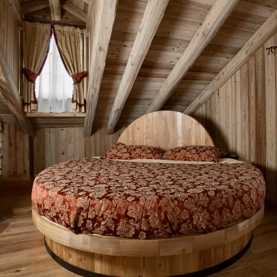 Letto rotondo della suite Archimede tra i tronchi di betulla