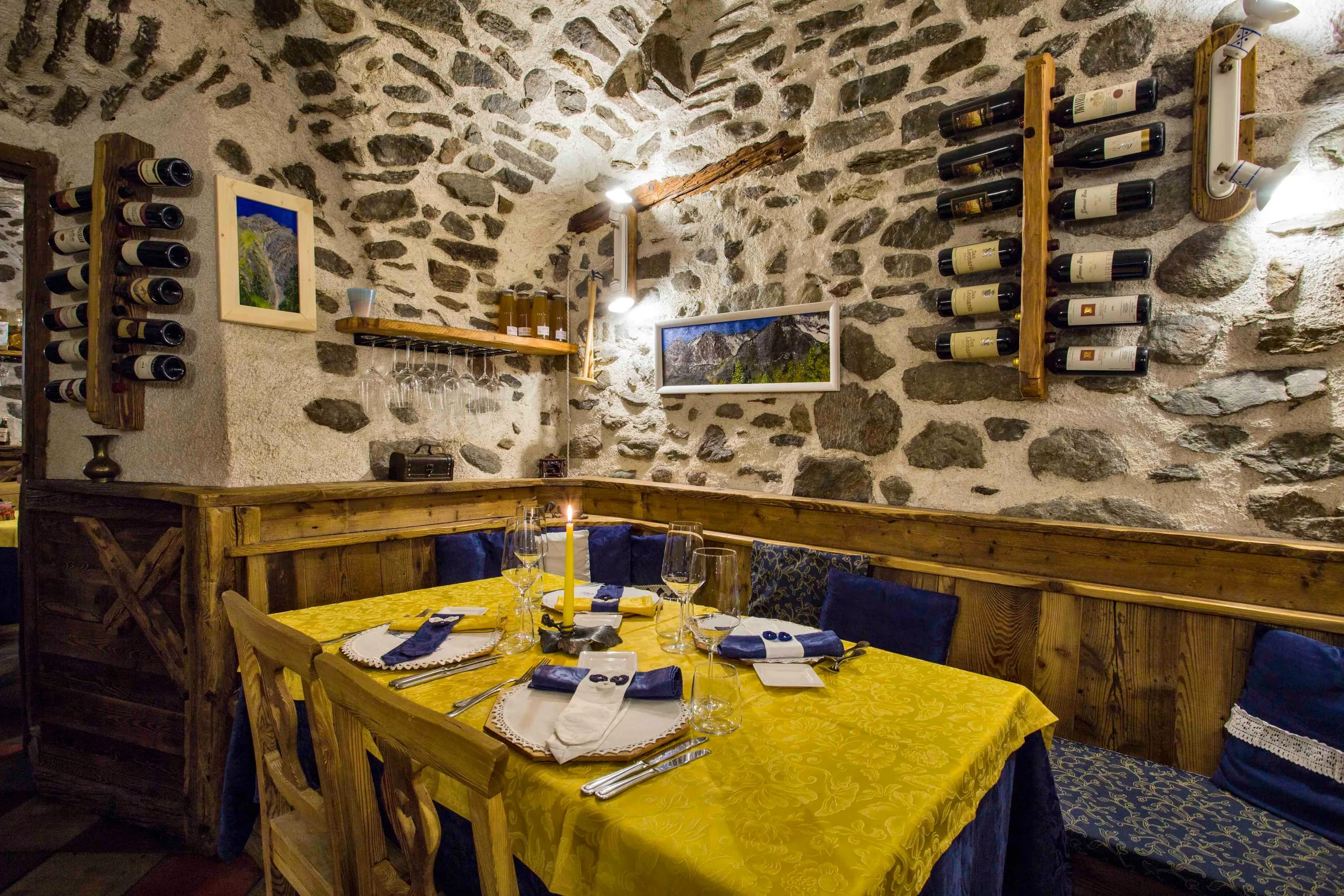 Angolo dell'osteria con le panche imbottite sotto la volta in pietra
