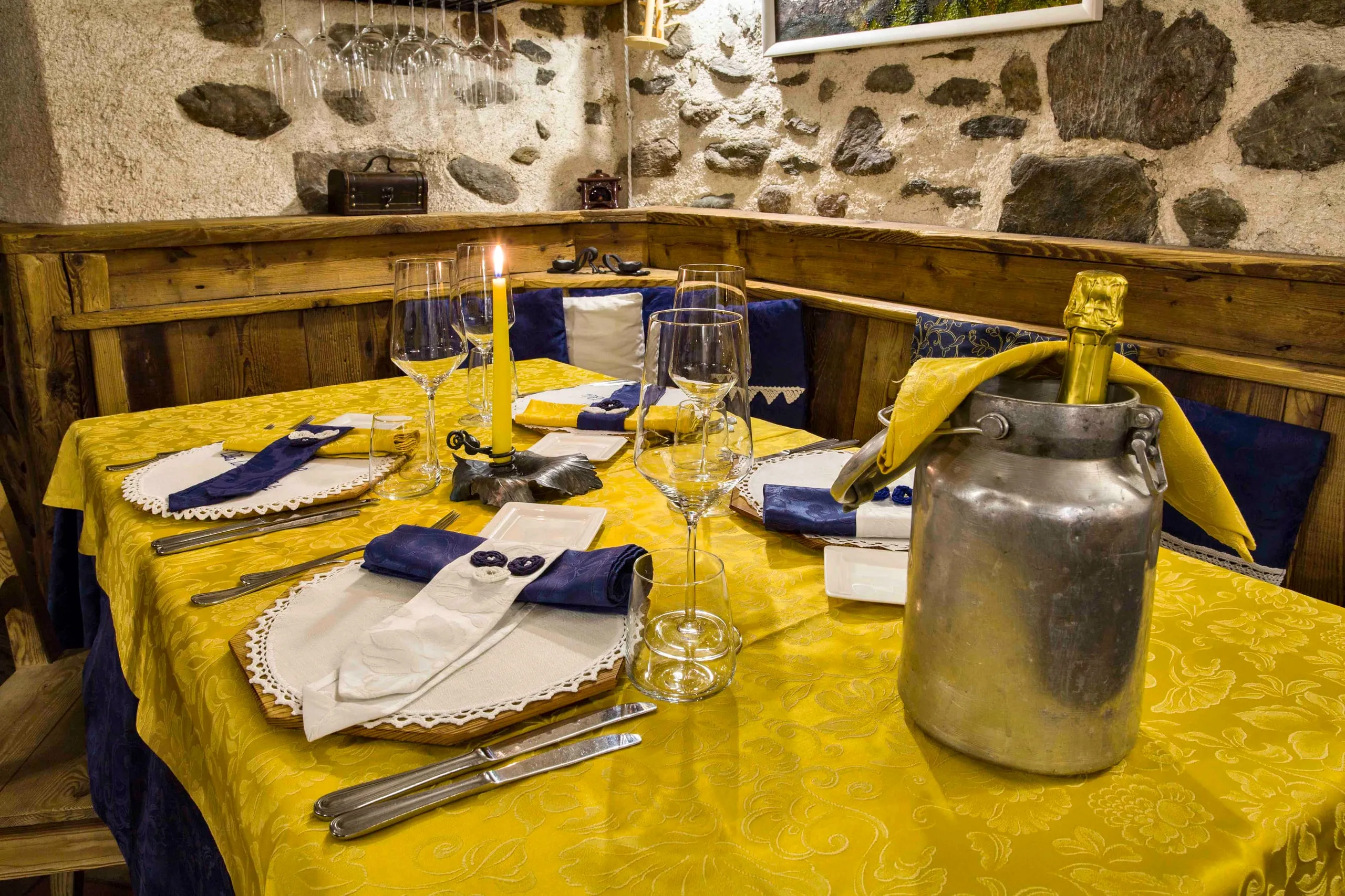 Tavolo apparecchiato con il secchiello del vino in metallo