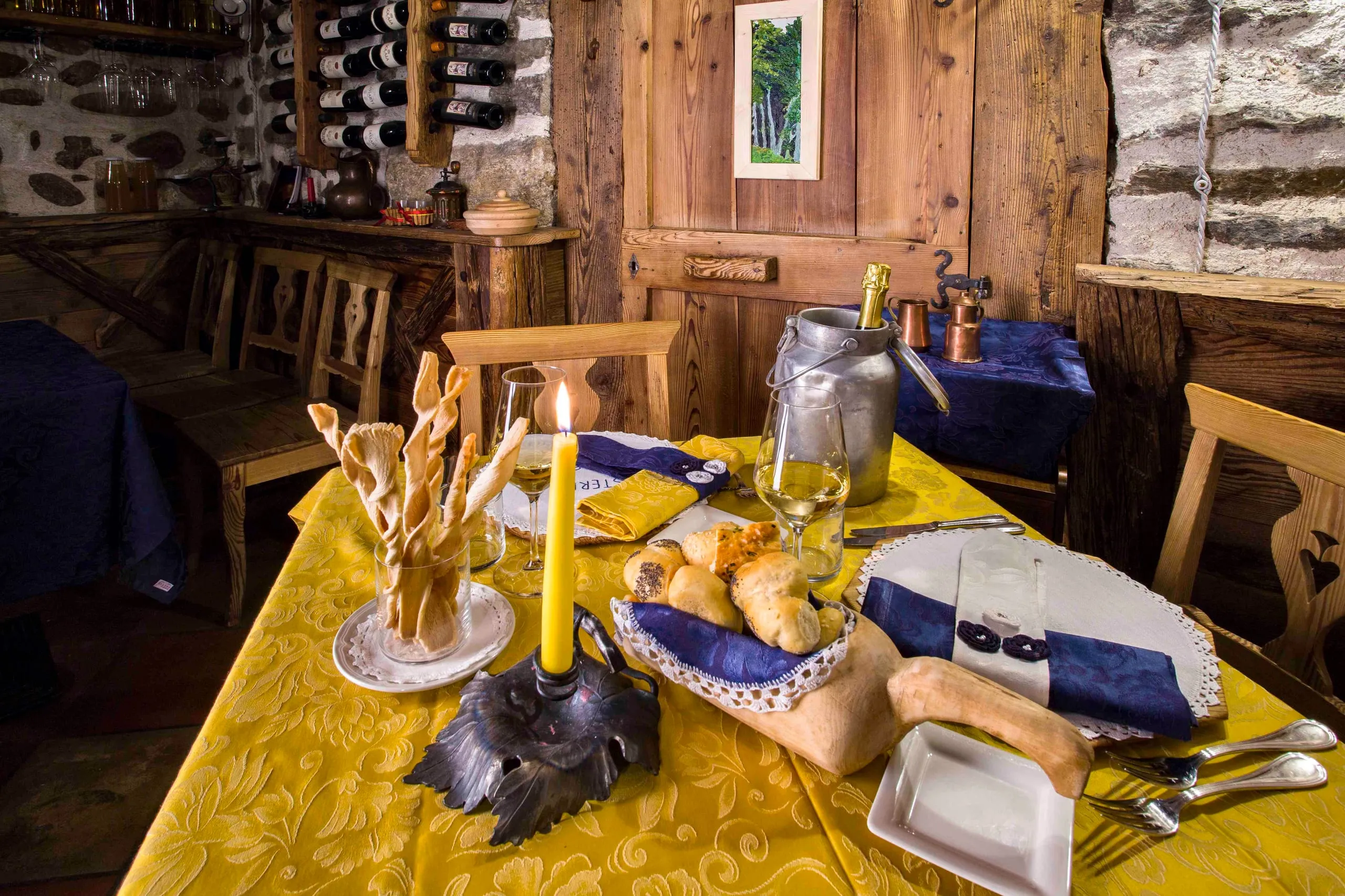 Tavolo con il cestino del pane e la candela davanti alla porta in legno