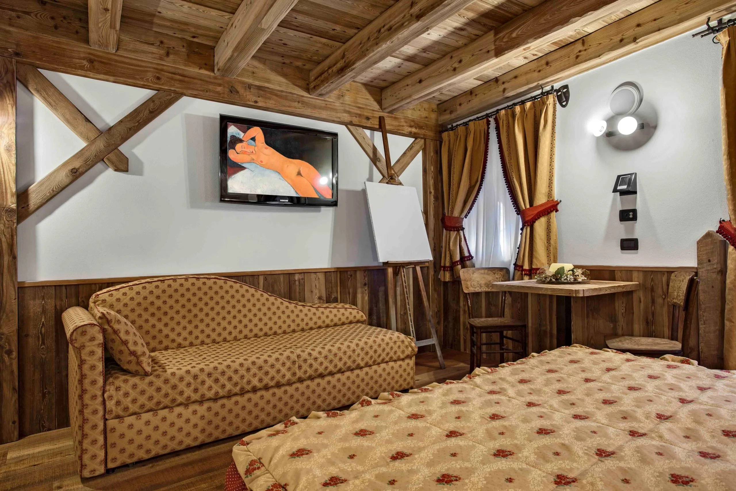 Divano, televisore e tavolo della suite Amedeo Modigliani