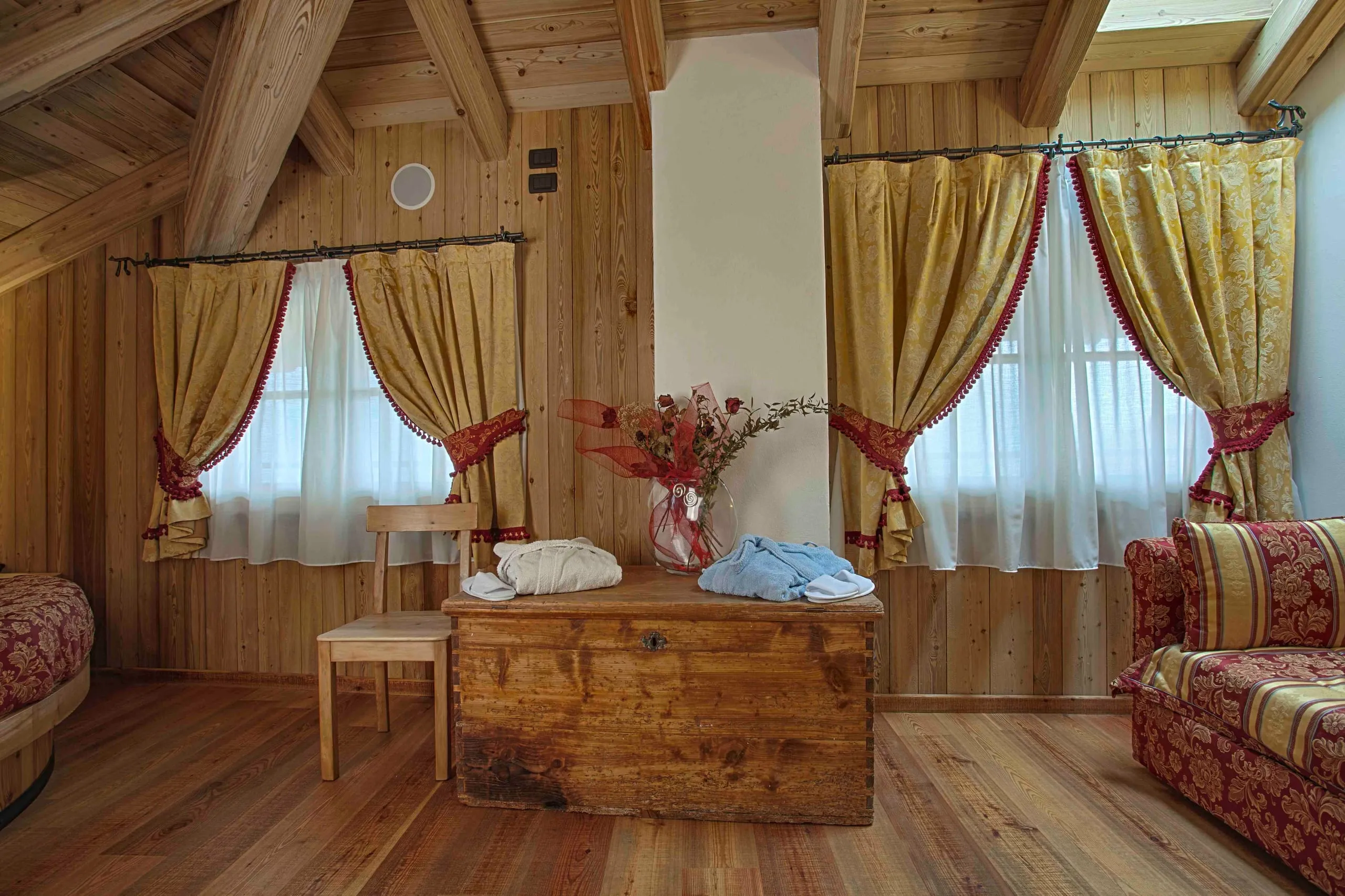 Cassapanca in legno tra le finestre della suite Archimede