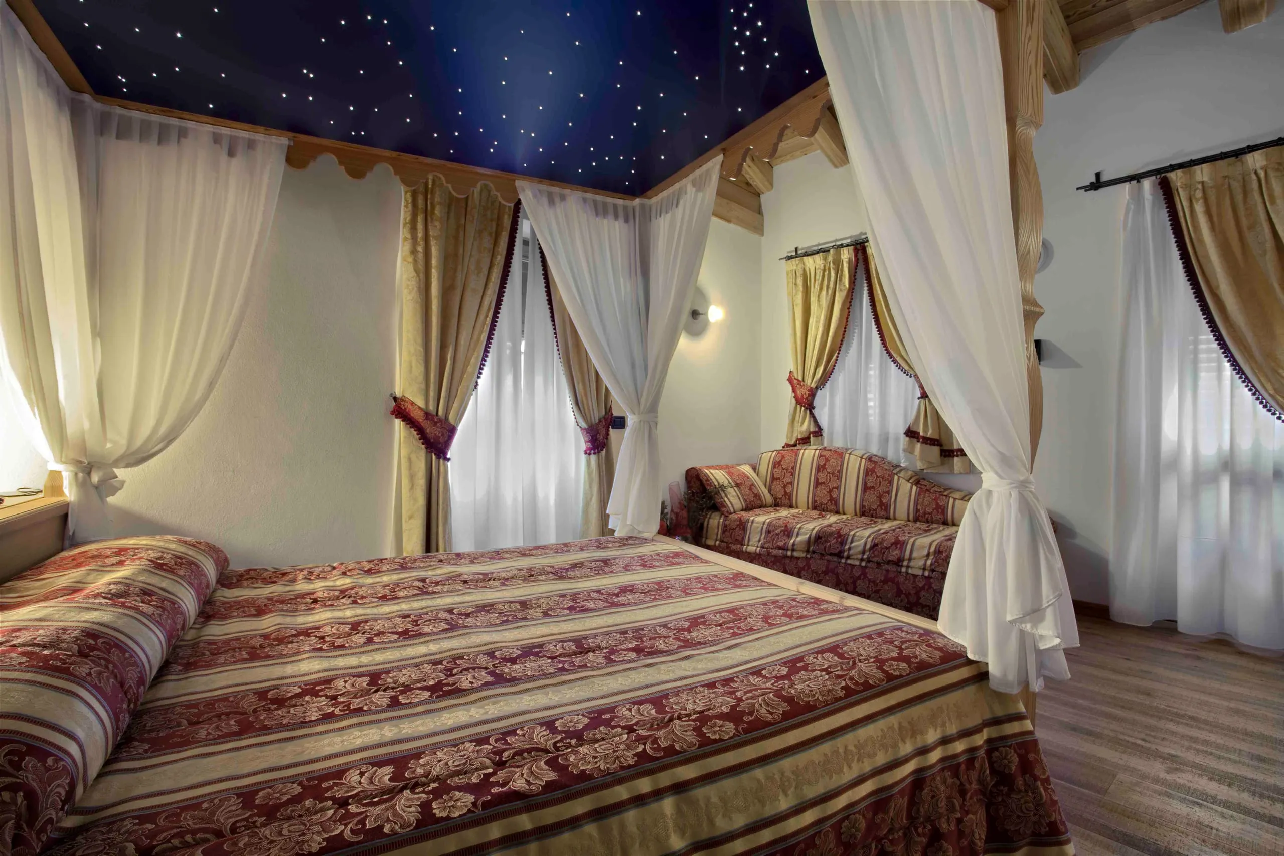 Letto a baldacchino e divano della suite Fabrizio De André