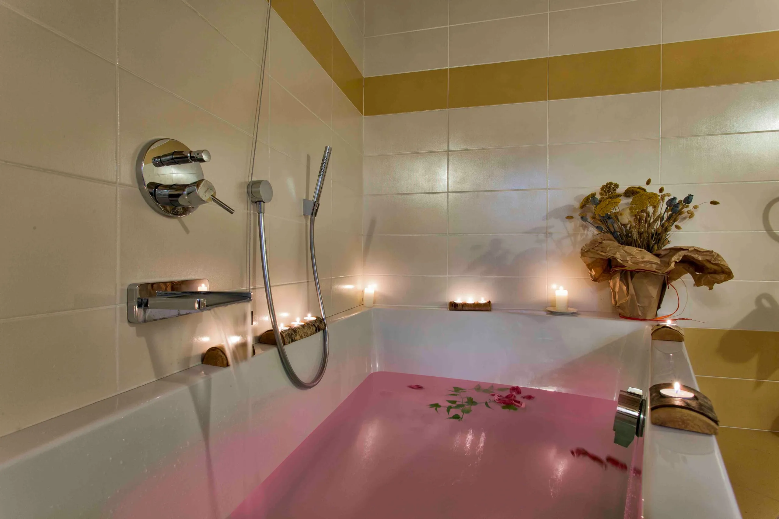 Vasca con l'acqua rosa e le candele