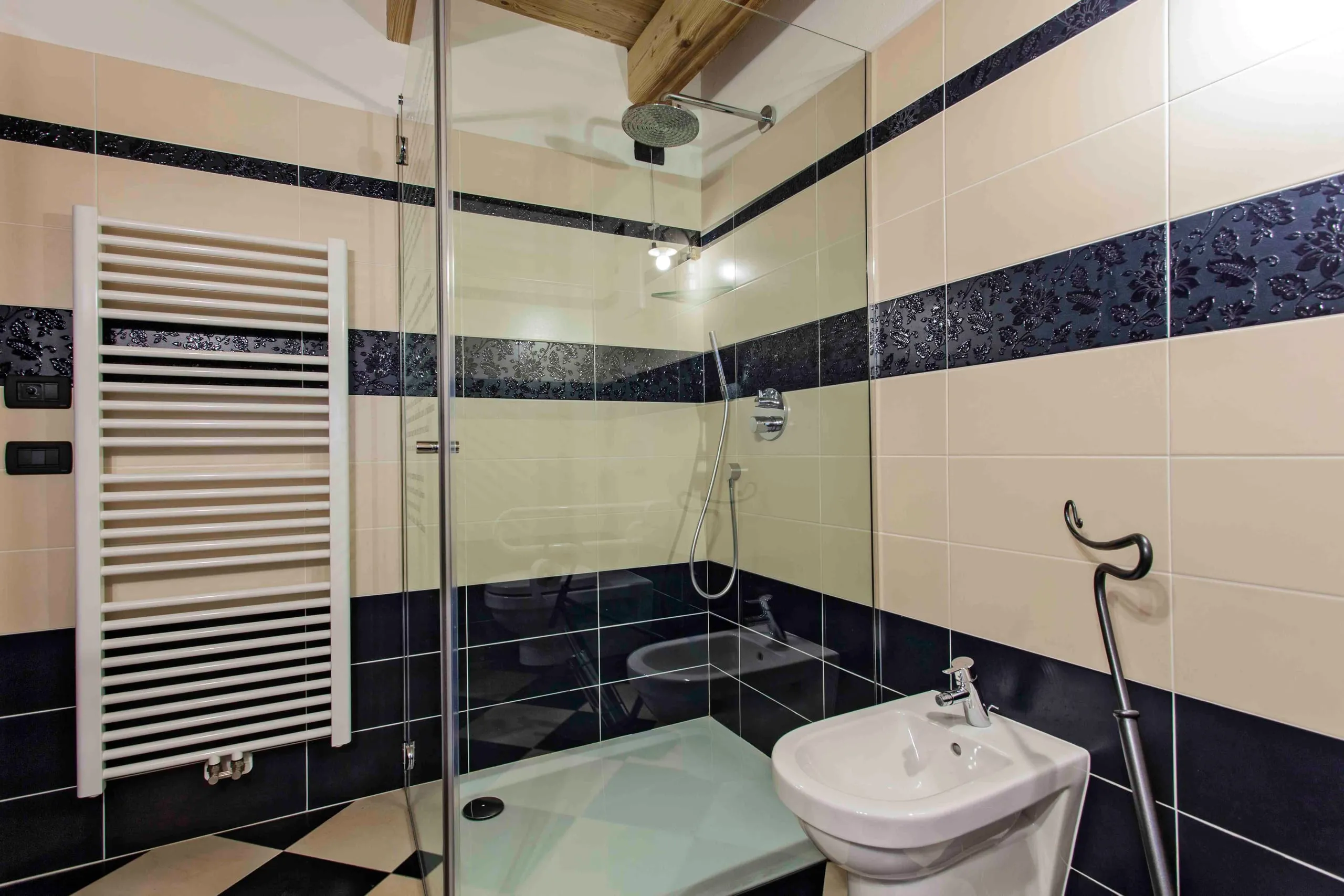 Bagno con doccia e pavimento a scacchi della suite Marco Pantani